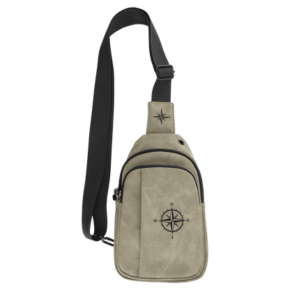 Light green Creekside Collection Explorer sling bag with a compass engraved on the front and top of the strap