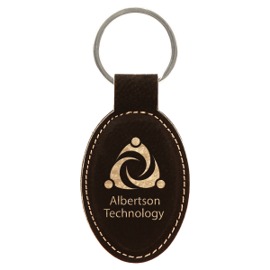 Black oval leatherette keychain with the Albertson Technology logo and metallic gold engraving