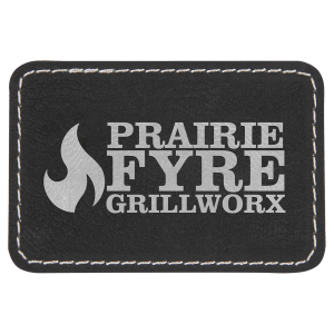 Prairie Fyre Grillworx logo on a black rectangular leatherette patch with silver stitching