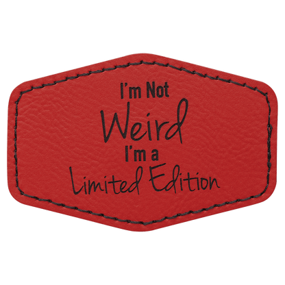 A red leatherette hexagon patch with black stitched edges, featuring the text "I'm Not Weird I'm a Limited Edition" in a mix of block and script lettering.