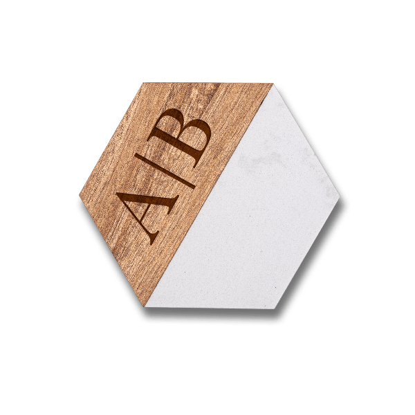 Custom engraved hexagonal marble and acacia wood coaster set featuring a personalized monogram on the natural wood grain.