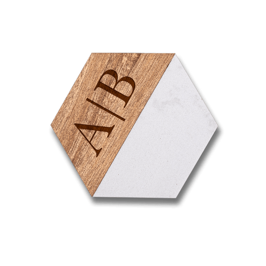 Custom engraved hexagonal marble and acacia wood coaster set featuring a personalized monogram on the natural wood grain.