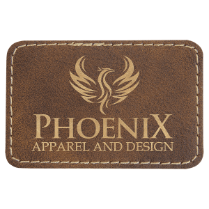 A brown faux-leather patch with stitched edges, featuring a gold phoenix logo and the text 'PHOENIX APPAREL AND DESIGN' in gold.