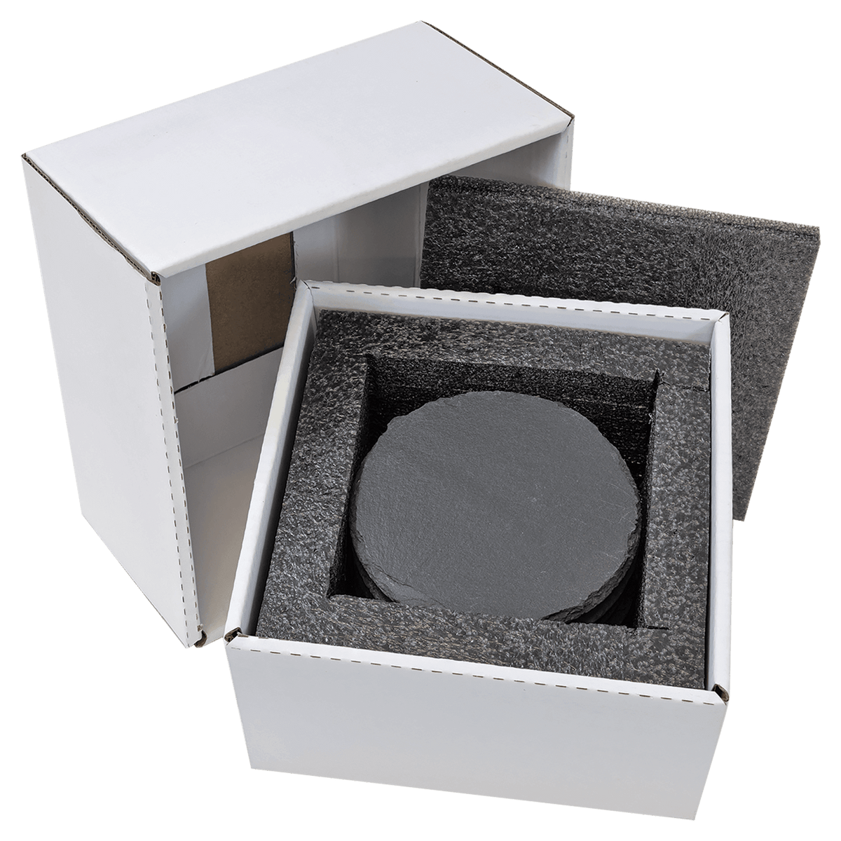 A high-angle studio shot of a white cardboard box partially open to reveal six round, black slate coasters neatly stacked inside protective black foam packaging.
